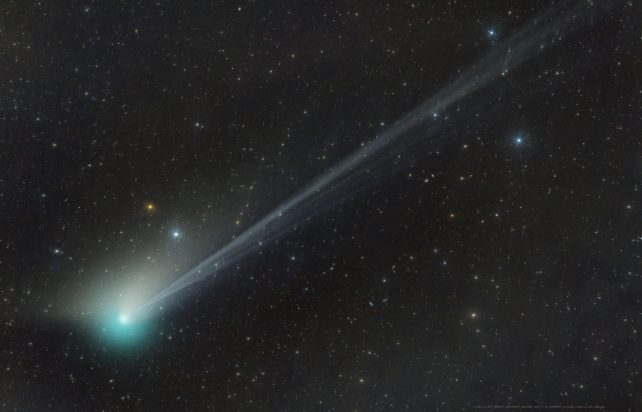 Blue-green comet zooming left across a starscape